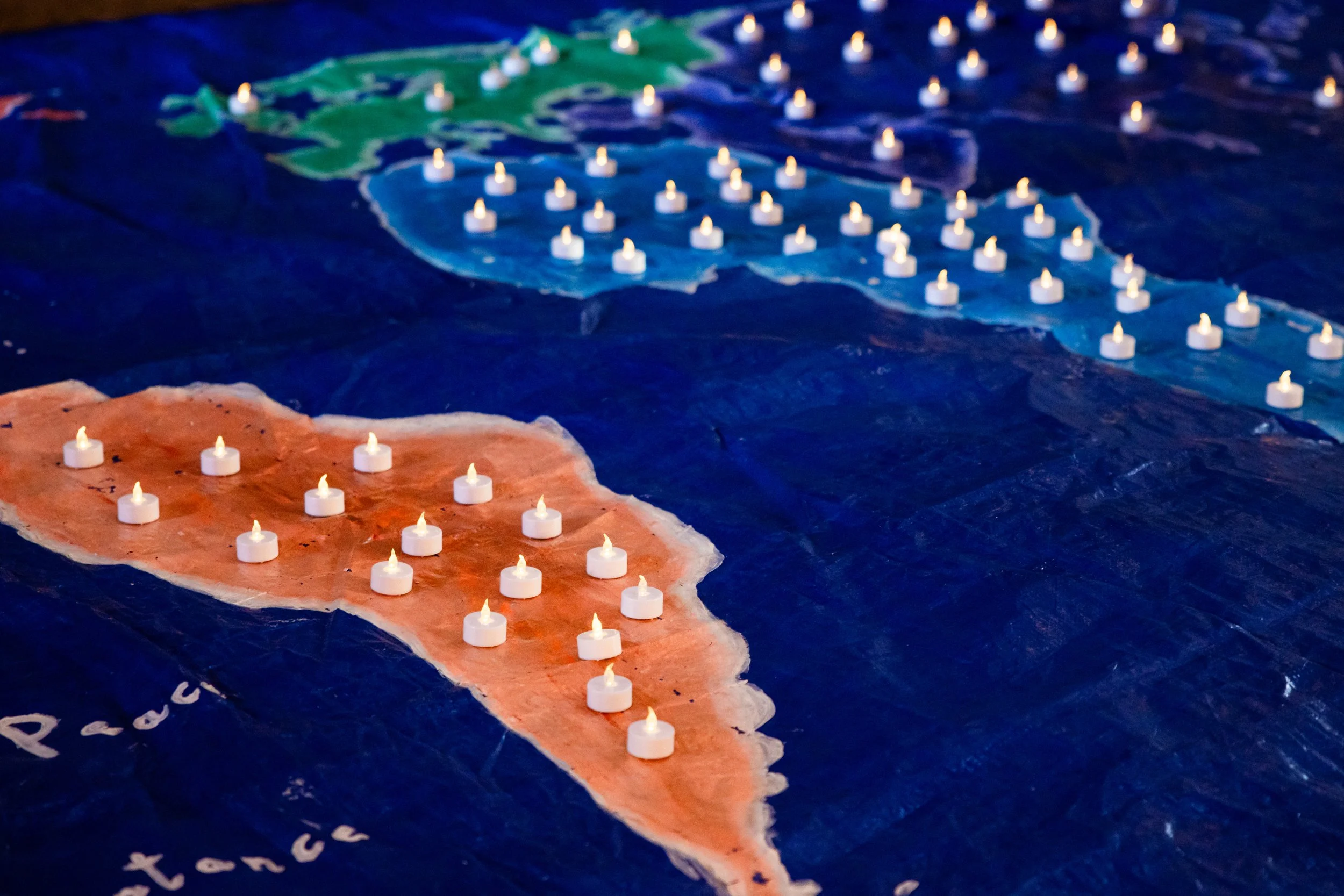 Close-up of the large world map with LED candles representing the 64 states where same-sex love is criminalised in 2025 and the 41 states where trans people died between November 2023 and October 2024.